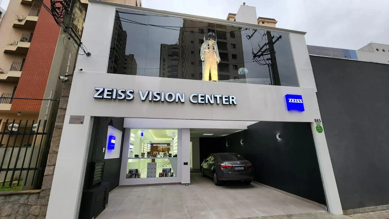 Fachada da ZEISS Vision Center Eixo Platina na R. Padre Estevão Pernet, 865, com o letreiro iluminado e a vitrine da loja